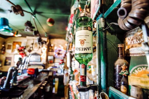 Spirit bottles and bric-a-brac crowding the shelves behind the bar