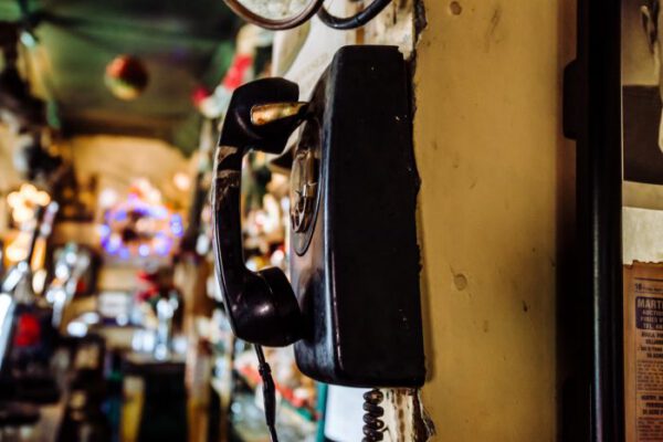 A vintage black rotary telephone mounted on the pub wall