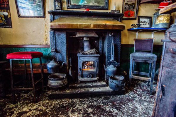 The cast-iron stove and fireplace with stools drawn up around it