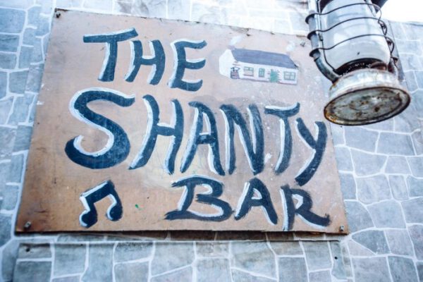 The hand-painted Shanty Bar sign on the stone wall outside