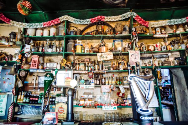 Shelves behind the bar packed with bottles, ornaments and Christmas decorations