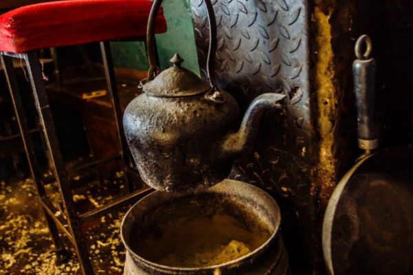 An old copper kettle and cooking pot beside the stove
