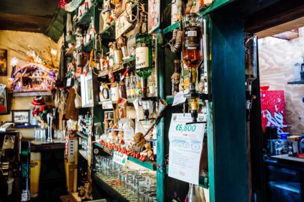 A crowded corner of shelves stacked with bottles and curiosities