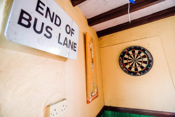 An “End of Bus Lane” sign hanging beside a dartboard