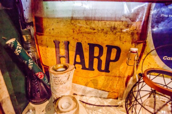 An old Harp lager sign propped against the wall