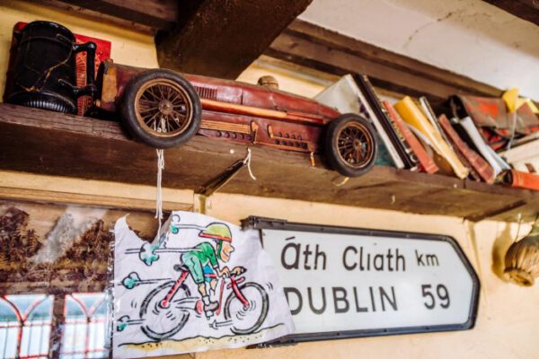 An Irish road sign for Dublin beside an old toy car
