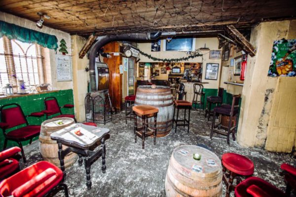 A room with barrels, red stools and the cast-iron stove