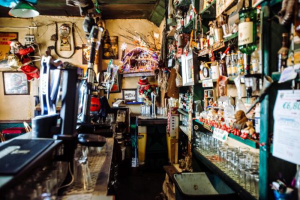 The bar counter with taps and shelves crowded with bottles