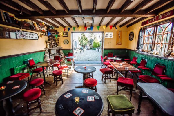 A snug with a round table, red stools and pictures covering the walls